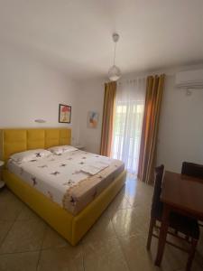 a bedroom with a bed and a table and a desk at Vila Tani in Ksamil