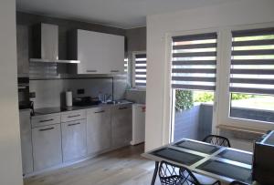 a kitchen with white cabinets and a table and a window at I&D Apartments in Duisburg