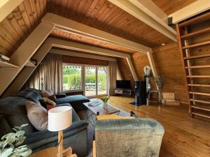 a living room with two blue couches and a table at Nur-Dach-Haus am Alfsee in Rieste