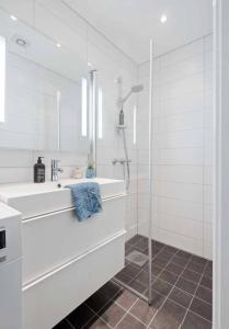 a white bathroom with a sink and a shower at Stylish 1-bedroom Oslo apartment in Oslo