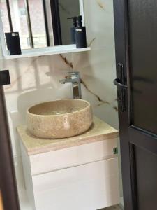 a bathroom sink with a stone bowl on a counter at Dream House borjomi sadgeri in Sadgeri