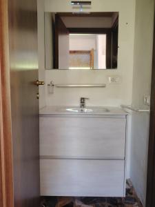 ein Badezimmer mit Waschbecken und Spiegel in der Unterkunft Casa di Caterina in Castiglioncello