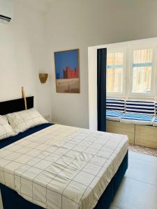 a bedroom with a large bed and two windows at Sea View Duplex - Sliema Centre in Il-Gżira taʼ Forti Manoel