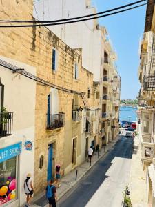 a group of people walking down a street with buildings at Sea View Duplex - Sliema Centre in Il-Gżira taʼ Forti Manoel