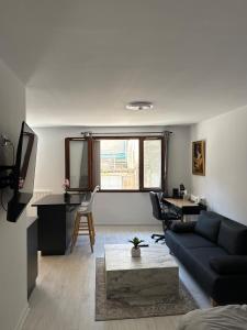 a living room with a blue couch and a table at Le temple, moderne et élégant Cœur de Limoges in Limoges +18 photos
