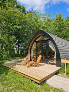 a gazebo with chairs on a wooden deck at Tiny House De Bosksjonger in Westergeest