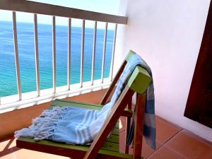 a chair on a balcony with a view of the ocean at O som das ondas - vista soberba de mar in Sesimbra