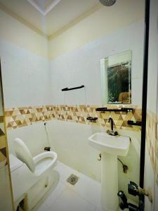 a bathroom with a toilet and a sink at AL AQSA SUiTES Guest House Islamabad in Islamabad +32 photos