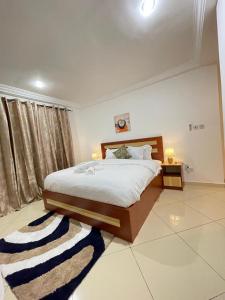 a bedroom with a large bed and a rug at Sunny's Place Luxury Apartments in Accra +11 photos
