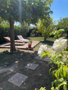 a garden with a picnic table and a tree at Le grand air, mobil-home XXL in Lattes
