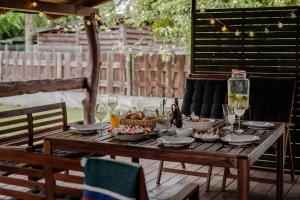 a wooden table with food and wine glasses on it at Dom Góra na Mazurach Balia z jacuzzi in Góra