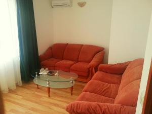 a living room with a red couch and a glass table at Guest House Rona - Free Parking and Sea View in Sveti Vlas