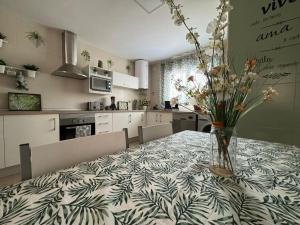 a kitchen with a table with a vase of flowers on it at La Casa del Cerezo in Nambroca