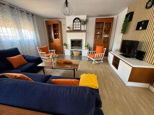 a living room with a blue couch and a table at La Casa del Cerezo in Nambroca