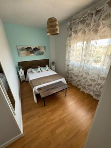 a bedroom with a bed and a bench in it at La Casa del Cerezo in Nambroca