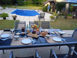 a blue table with food on it with a pool at Chambres d'hotes PROCHE CIRCUIT in Arnage