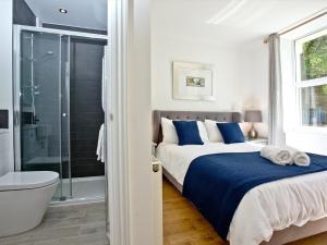 a bedroom with a bed and a shower and a tub at 5 Devon Beach Court in Woolacombe