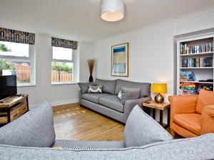 a living room with a couch and a tv at 5 Devon Beach Court in Woolacombe