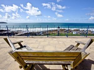 a wooden bench sitting in front of the ocean at 5 Devon Beach Court in Woolacombe