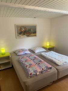 two beds in a room with two lamps on tables at Charmerende feriehus tæt på Knuthenborg in Maribo