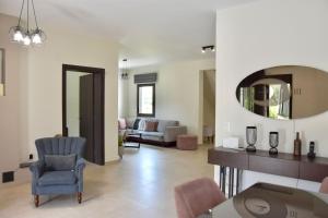 a living room with a couch and a mirror at Luxury rental villa for 14 people in Vourvourou +65 photos