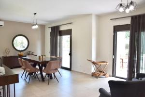 a dining room and living room with a table and chairs at Luxury rental villa for 14 people in Vourvourou