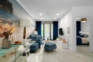 a living room with blue furniture and a bedroom at Eden Sea in Międzyzdroje