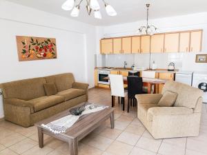 a living room with two couches and a table at Maisonette Wave in Metamorfosi