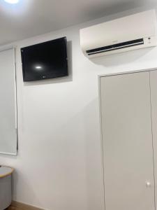 a room with a tv on a white wall at Hostal Jimena restaurante el Porvenir in Martiherrero