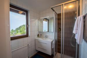 biała łazienka z umywalką i oknem w obiekcie Hotel Pension Tyrol w mieście Seefeld in Tirol