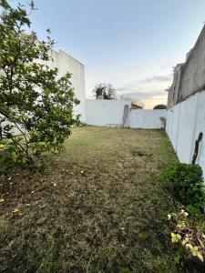 an empty yard with a white wall at Casa en alquiler in Tandil