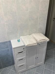 ein weißer Schrank in einem Badezimmer mit gefliester Wand in der Unterkunft Appartamento Bellavista in Roccella Ionica + 2 Fotos