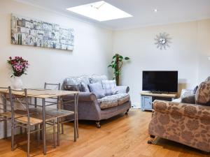 a living room with a couch and a table and a tv at Teddys Cottage - Uk44685 in Burnopfield