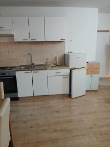 a kitchen with white cabinets and a sink at Željko apartmani in Zadar