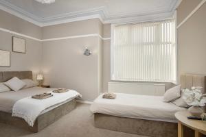 a bedroom with two beds and a window at Hotel Sofia Blackpool in Blackpool