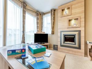 ein Wohnzimmer mit Tisch und Kamin in der Unterkunft Coastal Retreat in Ilfracombe