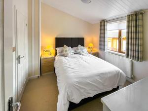 Un dormitorio con una cama blanca y una ventana. en Meadow View 16, en Ilfracombe 10 fotos más