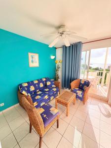 Una sala de estar con un sofá y sillas y una mesa. en Sea view apartment, pool and beach 50m away, en La Trinité 14 fotos más