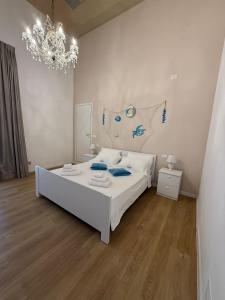 una camera da letto con un letto bianco e un lampadario di Clemente House Catania Centro MERAVIGLIOSA camera matrimoniale a Catania