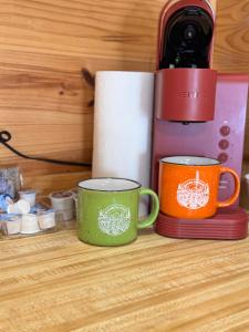 two coffee mugs sitting on a counter next to a bottle of wine at Ozark RV Park and Cabins in Mountain View