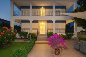 a house with a white door and some flowers at Villa Riviera in Stavros