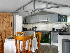 a kitchen with a table with chairs and an oven at Lake View Cottage in Belper