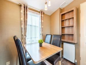 ein Esszimmer mit Tisch und Stühlen und einem Fenster in der Unterkunft Coastal Retreat in Ilfracombe