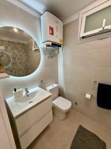 ロス・クリスティアーノスにあるAchacay Sunset Apartmentの洗面台、トイレ、鏡のあるバスルーム