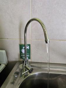 fregadero con grifo de agua en Valentyna Aparts El Chalten 4, en El Chaltén