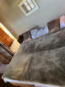 a bed with a blanket on it in a room at La Tranquilité in Saint-Didier-sur-Arroux