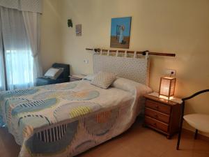 a bedroom with a bed and a table with a lamp at Apartamentos As Caldelas in O Grove