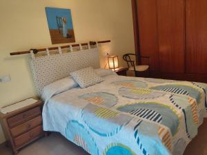 a bedroom with a bed with a colorful comforter at Apartamentos As Caldelas in O Grove
