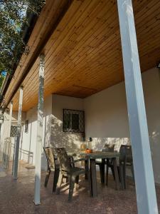 a patio with a table and chairs under a wooden ceiling at Ευχάριστη Βίλα, 90 μέτρα από τη θάλασσα in Agioi Theodoroi