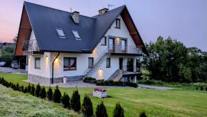 a large white house with a black roof at Apartament u Chowańców (blisko baseny termalne) in Bańska Niżna